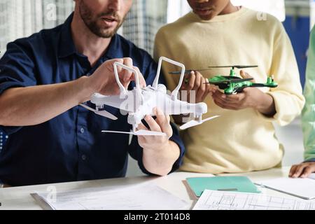 Zugeschnittenes Bild des Lehrers, das dem Schüler zeigt, wie Quadcopter eingeschaltet wird Stockfoto
