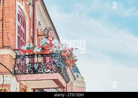 Kasan, Russland - 15. Juni 2023: Werbung für Straßenskulptur in Dekoration von Restaurant, Café. Wachstumszahl einer jungen Frau, die zwischen Blumen steht Stockfoto