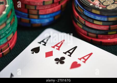 Vier Asse mit Casino-Chips auf dem Pokertisch Stockfoto