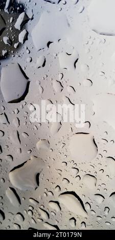 Regenwasser tropft auf das Dachglas Stockfoto