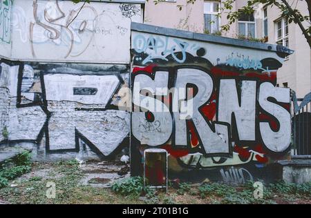 Urban Graffiti in Neighbourhood, um eine Botschaft zu senden und ansonsten langweilige, blinde Wände zu dekorieren. Berlin, Deutschland. Bild auf analogem, altem Kodak Film. Stockfoto