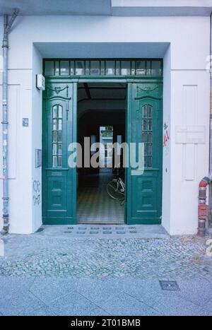 Eingangstür in Richtung eines Wohngebäudes im WinsViertel-Viertel. Berlin, Deutschland. Bild auf analogem, altem Kodak Film. Stockfoto