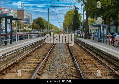 Lange, gerade Doppelschienen einer elektrischen Straßenbahn in einem modernen Wohngebiet in den Haag, Niederlande Stockfoto