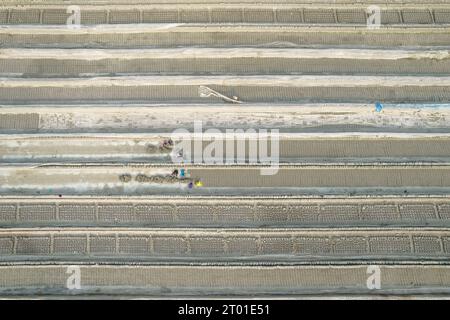 Barishal, Bangladesch. Oktober 2023. Die Arbeiter sind von Millionen von neu geschaffenen Ziegeln in einer Fabrik umgeben. In der Fabrik in Bangladesch wurden die erstaunlich vielen Ziegelsteine in langen Reihen gelagert, die sich so weit das Auge reicht. Luftaufnahmen zeigen, wie Arbeiter die grauen Ziegelsteine durchsuchen, bevor sie in Öfen gebracht werden, um sie fertig zu machen. Arbeiter, die schwer beladene Wagen durch Reihen von Tausenden von Ziegeln schoben, ließen trocknen. Jeder 2 kg schwere Tonziegel wird drei Tage lang in der Sonne getrocknet, bevor er in Öfen gebacken wird. (Foto: Mustasinur Rahman Alvi/SIPA USA) Credit: SIPA USA/Alamy Live News Stockfoto