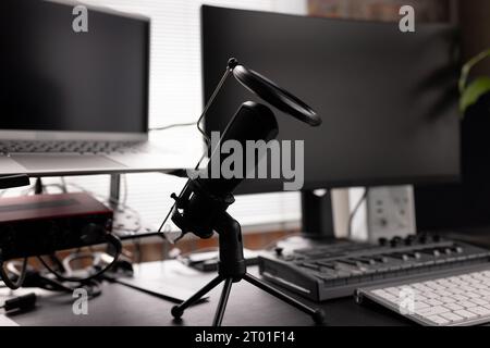 Podcasting mit Computern, Tastatur und Mikrofon zu Hause auf dem Schreibtisch Stockfoto