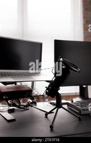 Podcasting mit Computern, Tastatur und Mikrofon auf dem Schreibtisch zu Hause, Kopierraum Stockfoto