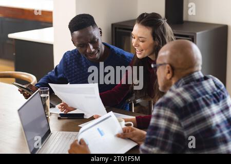 Diverse Ehepaare und männliche Finanzberater mit Laptop und diskutieren zu Hause über Dokumente Stockfoto