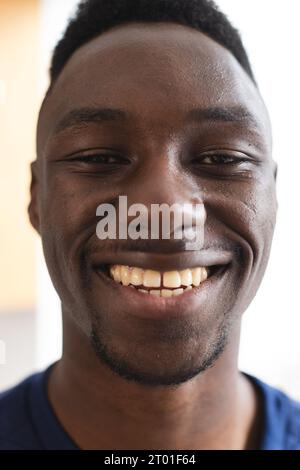 Porträt eines glücklichen afroamerikanischen Mannes mit kurzen schwarzen Haaren, die zu Hause lächeln Stockfoto