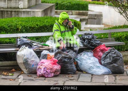 Obdachloser Taschenmann, der auf dem Handy in Preston, Lancashire spricht. Oktober 2021. Ein Obdachloser, der durch die Straßen der Stadt streift und seine Besitztümer in mehreren Taschen trägt. Verzweifelte Obdachlose in Preston kehren auf die Straße zurück, als Notunterkünfte, in denen während der Pandemie raue Schläfer untergebracht wurden, wieder aufgelöst sind. Stockfoto