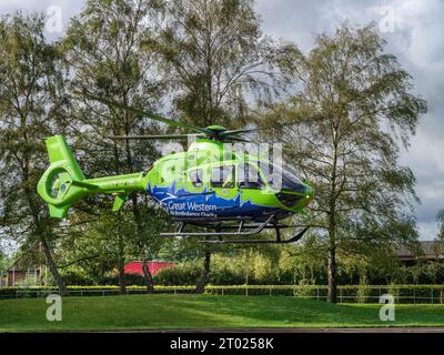 Der Great Western Air Ambulance hebt vor dem Gloucester Royal Hospital ab. Der hellhellhellgrüne und blaue Hubschrauber, Rufzeichen Helimed 65, ist Stockfoto