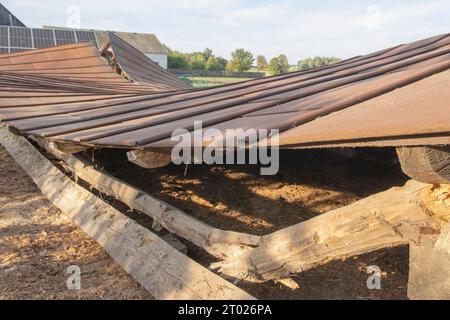 Die Überreste eines alten, zerstörten Metalldachs liegen nach dem Abriss der Scheune auf dem Boden. Tag Stockfoto