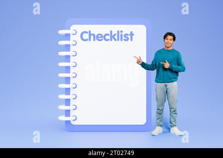 Fröhlicher junger koreanischer Mann zeigt mit den Fingern auf eine große Checkliste mit freiem Platz Stockfoto