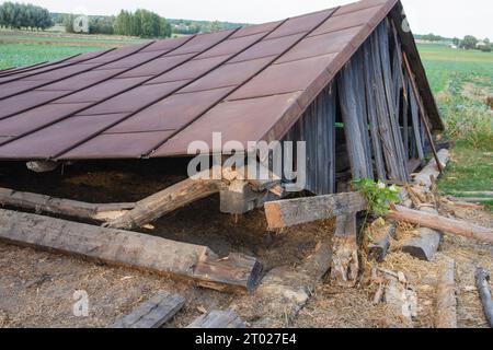 Die Überreste eines alten, zerstörten Metalldachs liegen nach dem Abriss der Scheune auf dem Boden. Tag Stockfoto