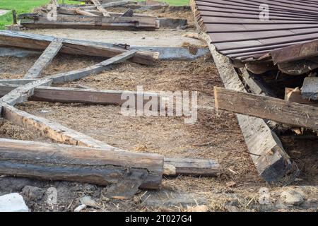 Die Überreste eines alten, zerstörten Metalldachs liegen nach dem Abriss der Scheune auf dem Boden. Tag Stockfoto