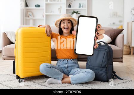 Aufgeregte junge indische Touristin, die ein Telefon mit leerem Bildschirm zeigt Stockfoto