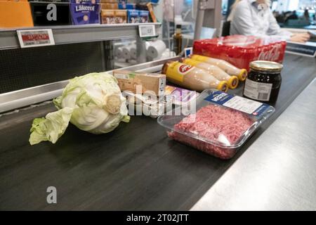 Die Waren auf dem Förderband des Supermarktes warten auf den Kassierer. Stockfoto