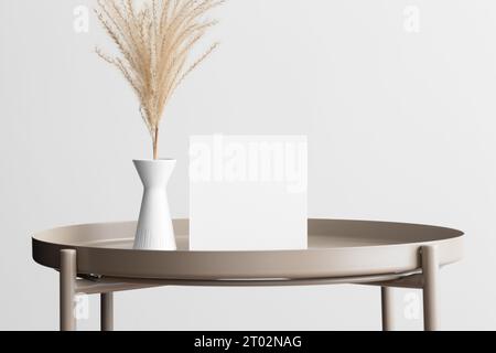 Quadratische Einladungskarte Mockup mit getrocknetem Blumenschmuck auf dem beigen Tisch. Stockfoto