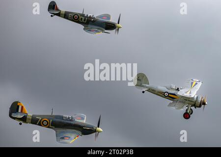 Ein Gladiator, Spitfire und Sea Hurricane fliegen zusammen auf der Shuttleworth Collection Race Day Air Show 2023. Stockfoto