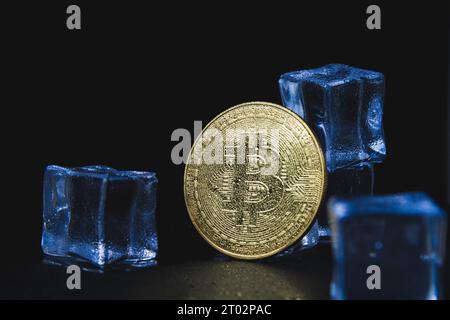 Eis und Bitmünze. Einfrieren von Konten mit Kryptowährung. Gefrorene Bitcoin-Münze. Stockfoto
