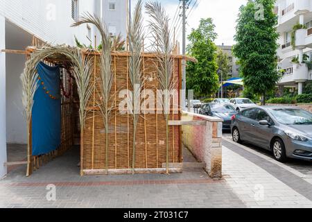 Rishon LeZion, Israel - 1. Oktober 2023: Sukkah auf der Straße in der Nähe eines Wohngebäudes in der israelischen Stadt während des jüdischen Feiertags Sukkot Stockfoto