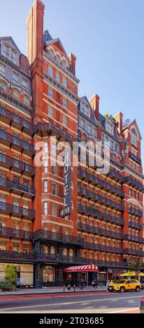 Das Hotel Chelsea dominiert den Block mit seiner dunkelroten Fassade, markanten Balkonen aus Eisen und einem dreistöckigen beleuchteten Schild an der 222 W 23rd Street in Midtown. Stockfoto