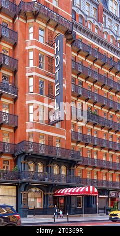 Das Hotel Chelsea dominiert den Block mit seiner dunkelroten Fassade, markanten Balkonen aus Eisen und einem dreistöckigen beleuchteten Schild an der 222 W 23rd Street in Midtown. Stockfoto