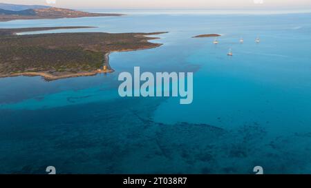 Luftbild der Insel Isola Piana in der Nähe von Stintino und des Strandes von Spiaggia La Pelosa. Bergige Insel, blaues Wasser und klarer Himmel. Stockfoto