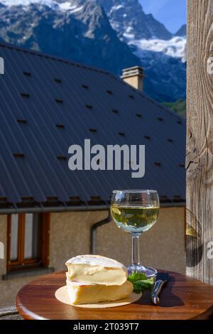 Französischer Reblochon-Käse aus Haute-Savoie, Weißwein Roussette de Savoie oder Vin de Savoie mit Blick auf das alte Alripne-Dorf und den Berg Hautes Alpes Stockfoto