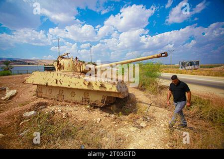 Northen Valley, Palästina. Oktober 2023. Ein Mann läuft an einem alten israelischen Panzer vorbei, der im Jordantal im nördlichen Westjordanland gesehen wurde. Die israelischen Behörden eroberten die Ländereien der palästinensischen Bewohner des Jordantals, deportierten sie und errichteten Schulen in einigen Teilen des Landes. (Foto: Nasser Ishtayeh/SOPA Images/SIPA USA) Credit: SIPA USA/Alamy Live News Stockfoto