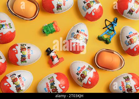 Sveti Vlas, Bulgarien - 26. Juni 2023: Kinder Überraschungseier, Plastikbehälter und Spielzeug auf orangem Hintergrund, flache Lay Stockfoto