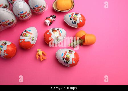 Sveti Vlas, Bulgarien - 26. Juni 2023: Kinder Überraschungseier, Plastikbehälter und Spielzeug auf rosafarbenem Hintergrund, flach liegend Stockfoto