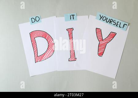 Phrase Do IT Yourself und Abkürzung DIY aus Buchstaben auf hellgrauem Hintergrund, flach gelegt Stockfoto