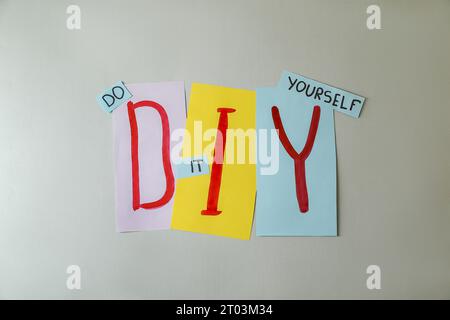 Phrase Do IT Yourself und Abkürzung DIY aus Buchstaben auf hellgrauem Hintergrund, flach gelegt Stockfoto