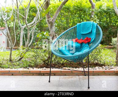 Ein grünes Handtuch mit Blumen wird auf den Stuhl gelegt. Stockfoto