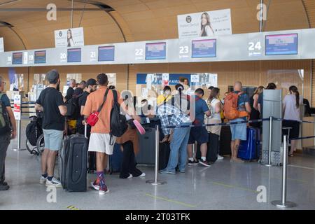 Posen, Polen - 25. August 2023: Personen stehen an den Check-in-Schaltern am Flughafen Posen Lawica an. Stockfoto