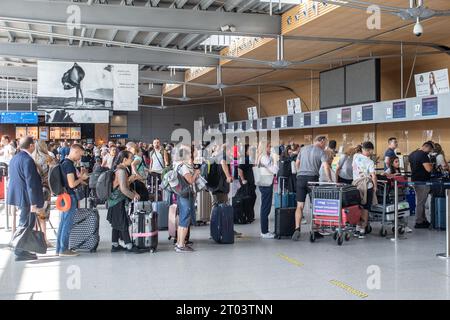 Posen, Polen - 25. August 2023: Personen stehen an den Check-in-Schaltern am Flughafen Posen Lawica an. Stockfoto