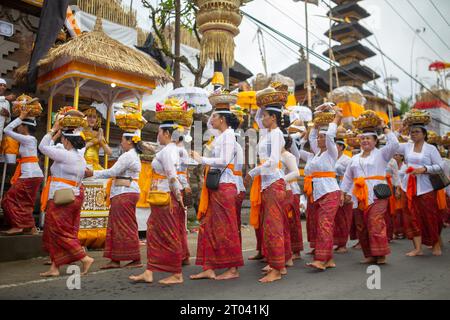 Bali, Indonesien - 16. September 2023: Balinesische Menschen werden bei einer traditionellen Zeremonie auf der Straße gesehen. Stockfoto