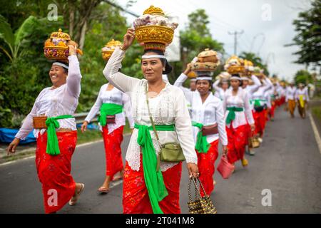 Bali, Indonesien - 16. September 2023: Balinesische Menschen werden bei einer traditionellen Zeremonie auf der Straße gesehen. Stockfoto