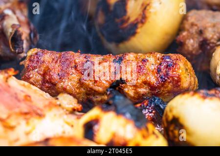 Traditionelle rumänischen Fleischbällchen "mici" auf dem Grill. Schmackhafte Fleischbällchen auf dem Grill, Schweinefleisch auf Holzkohlengrill Stockfoto