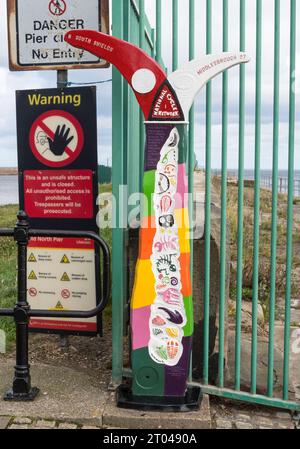 Ein hell gemalter Jahrtausendmeilenposten an der National Cycle Route 1 in Roker, Sunderland, England, Großbritannien Stockfoto