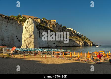 Der Sandstrand von Pizzomunno mit dem berühmten Meer und der Strand voller Sonnenschirme an einem heißen Spätsommertag. Vieste, Provinz Foggia, Apulien Stockfoto