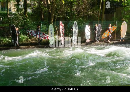 München Deutschland - Surfer stehen am Eisbach im Englischen Garten. Stockfoto