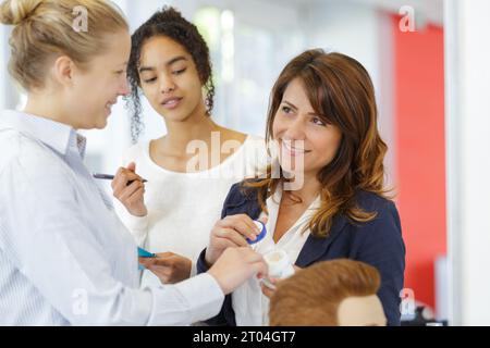 Friseurlehrling bügeln die Haare des Kunden Stockfoto