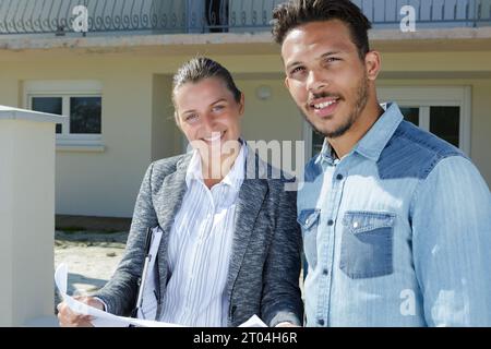 Ein Paar, das vor dem Haus steht und sich die Details des Hotels ansieht Stockfoto