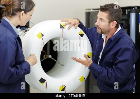 Lächelnder Mann und Frau reden über Motor Stockfoto