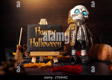 4. Oktober 2023: Herbst- und Halloween-Dekoration um eine Tafel mit Aufschrift: Happy Halloween. Skelett mit Hexenbesen gruselige KONZEPTFOTOMONTAGE *** Herbst und Halloween Dekoration um eine Kreidetafel mit Aufschrift: Happy Halloween. Skelett mit Hexenbesen Grusel Konzept FOTOMONTAGE Stockfoto