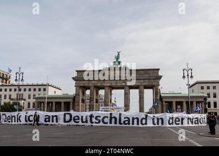 Berlin, Deutschland. Oktober 2023. Demonstranten mit einem Banner mit der Aufschrift "Ich denke an Deutschland in der Nacht", die während eines prorussischen Protestes vor dem Brandenburger Tor, dem Bundestag, der Kirche gesehen wurden. Der Fall der Berliner Mauer am 9. November 1989, der das Ende des Kalten Krieges markierte, hatte kaum ein Jahr später den Weg für die deutsche Wiedervereinigung geebnet. Der am 20. September 1990 unterzeichnete Einigungsvertrag, der den 3. Oktober zum Nationalfeiertag erklärte, besiegelte das Ende der Teilung Deutschlands. Quelle: SOPA Images Limited/Alamy Live News Stockfoto