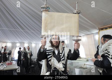 In einer Synagoge und nach einer Lesung hält ein Rabbiner die Thora, damit die Kongreganten die Briefe sehen und gesegnet werden können. Im Rockland County, New York. Stockfoto