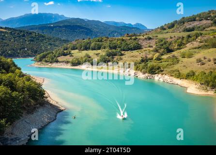 Ein Schnellboot von der Passerelle du DRAC (DRAC-Fußgängerbrücke) fährt den Montynard Avignonet Lake (Lac de Montynard-Avignonet) in den Ausläufern der A herunter Stockfoto