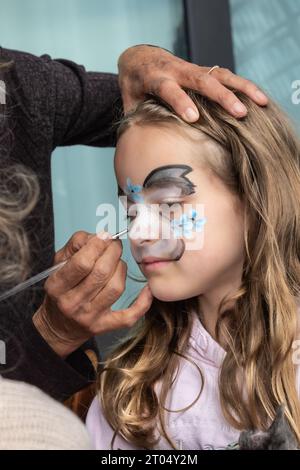 In einem skurrilen Moment purer Freude verwandelt sich ein kleines Mädchen mit Gesichtsfarbe Stockfoto